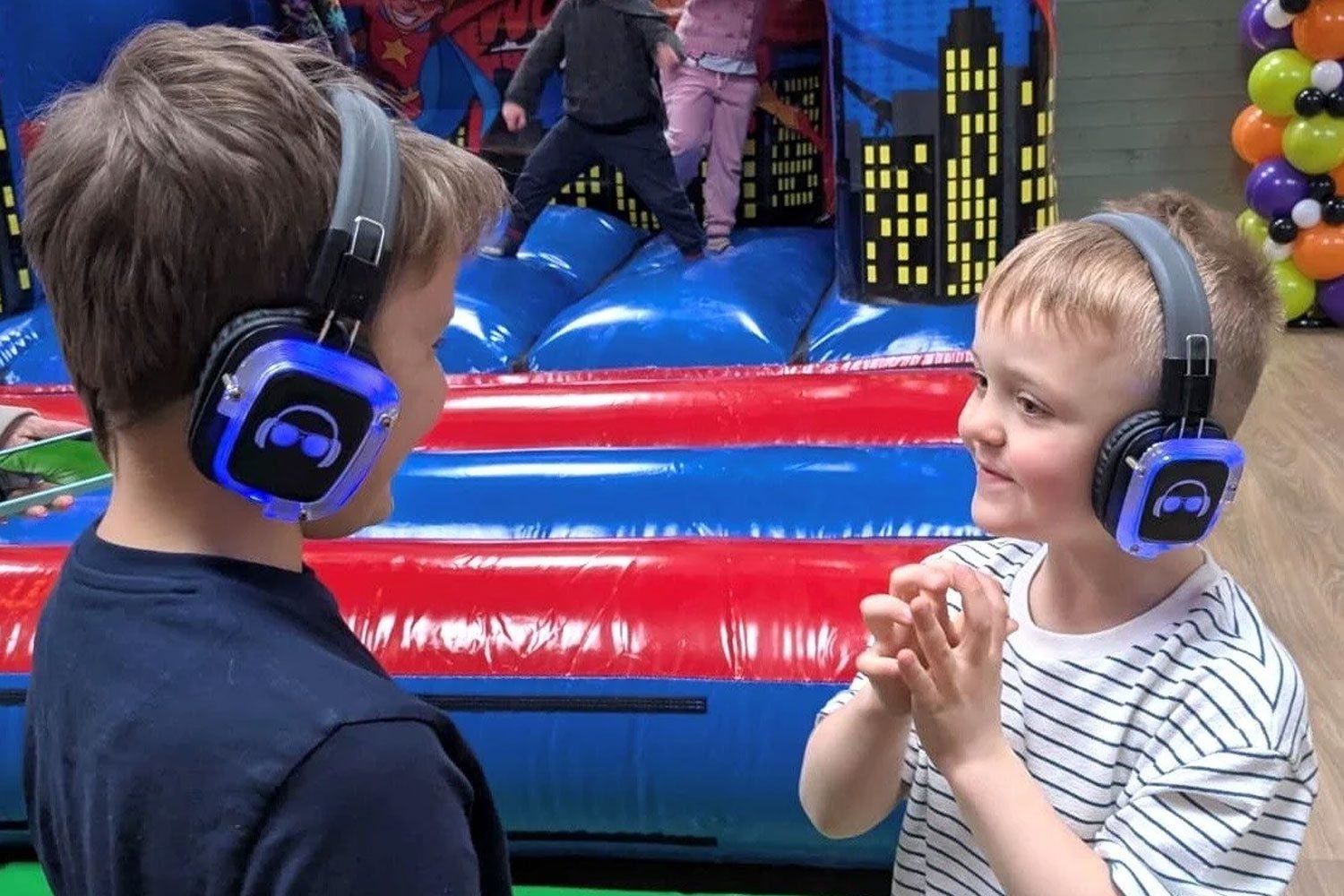 Children wearing headphones dancing at a silent disco event.