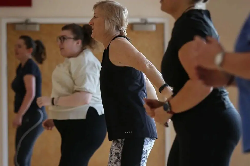 Adults participating in group fitness challenges and gym activities