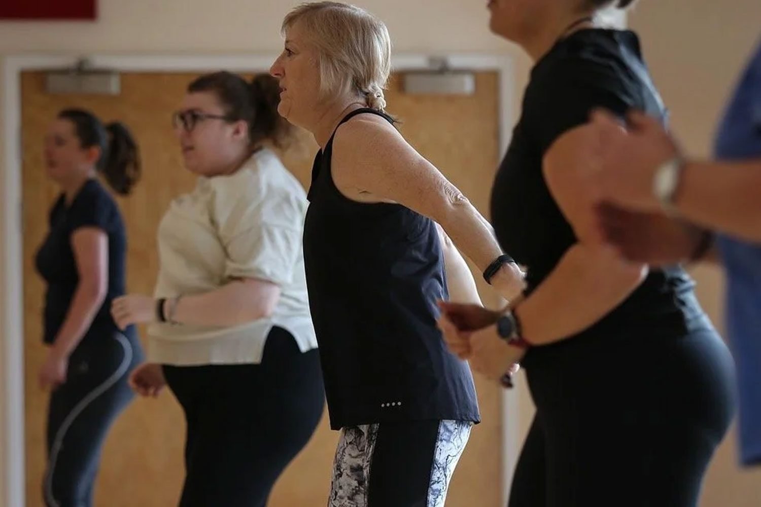 Adults participating in group fitness challenges and gym activities