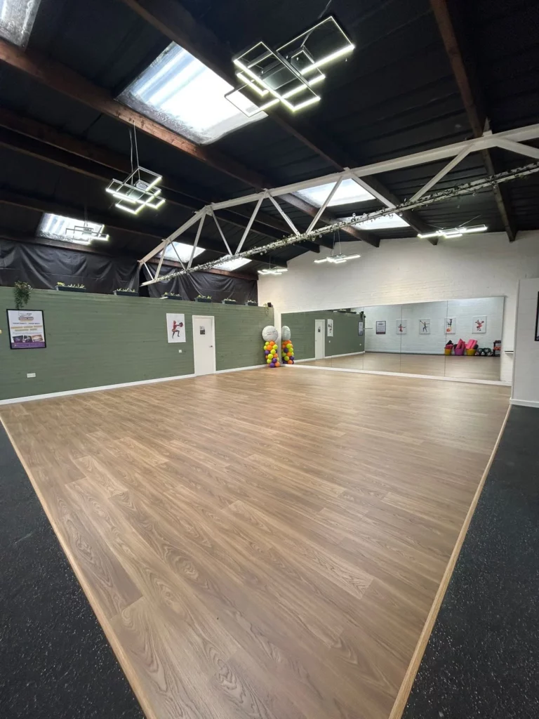 Spacious hall hire venue with wooden flooring, mirrors and modern lighting