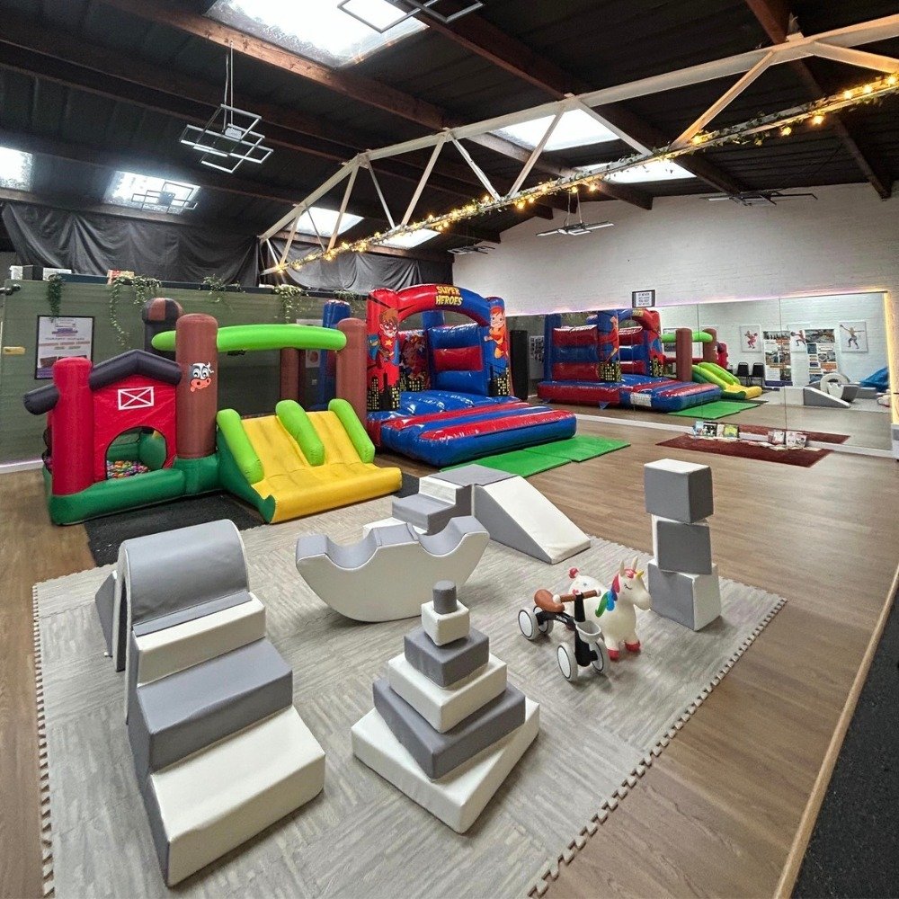 Indoor soft play area with bouncy castles and children’s play equipment