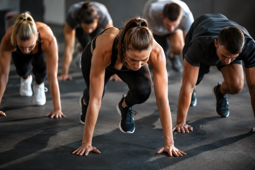 Group fitness class doing plank exercises in gym