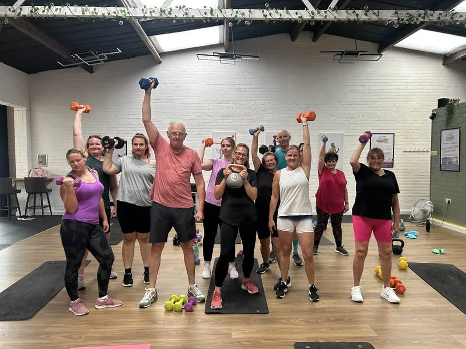 Group exercising with weights indoors.