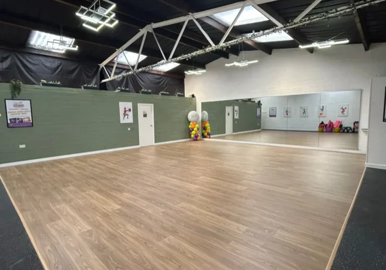 Spacious hall hire venue with wooden flooring, mirrors and modern lighting