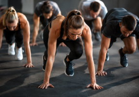 Group fitness class doing plank exercises in gym