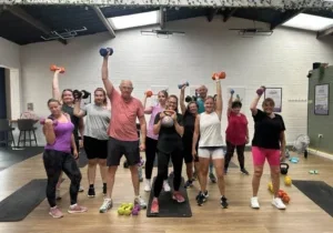Group exercising with weights indoors.